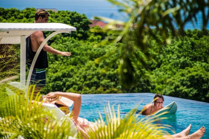 Surf coach guiding a student into a wave in Bali