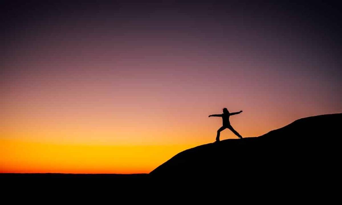 Outline of a girl on a mountain at sunset