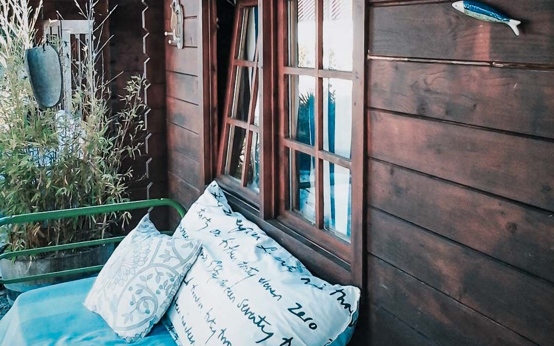 A small sitting area with couch and pillows on the outside lounge