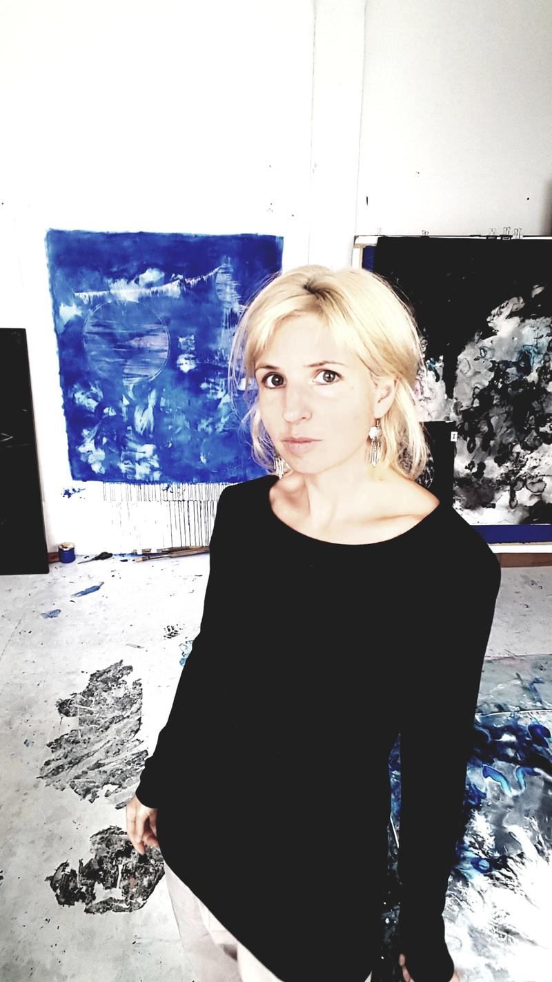 Portraitfoto von Jana Schumacher in ihrem Atelier zwischen Kunstwerken