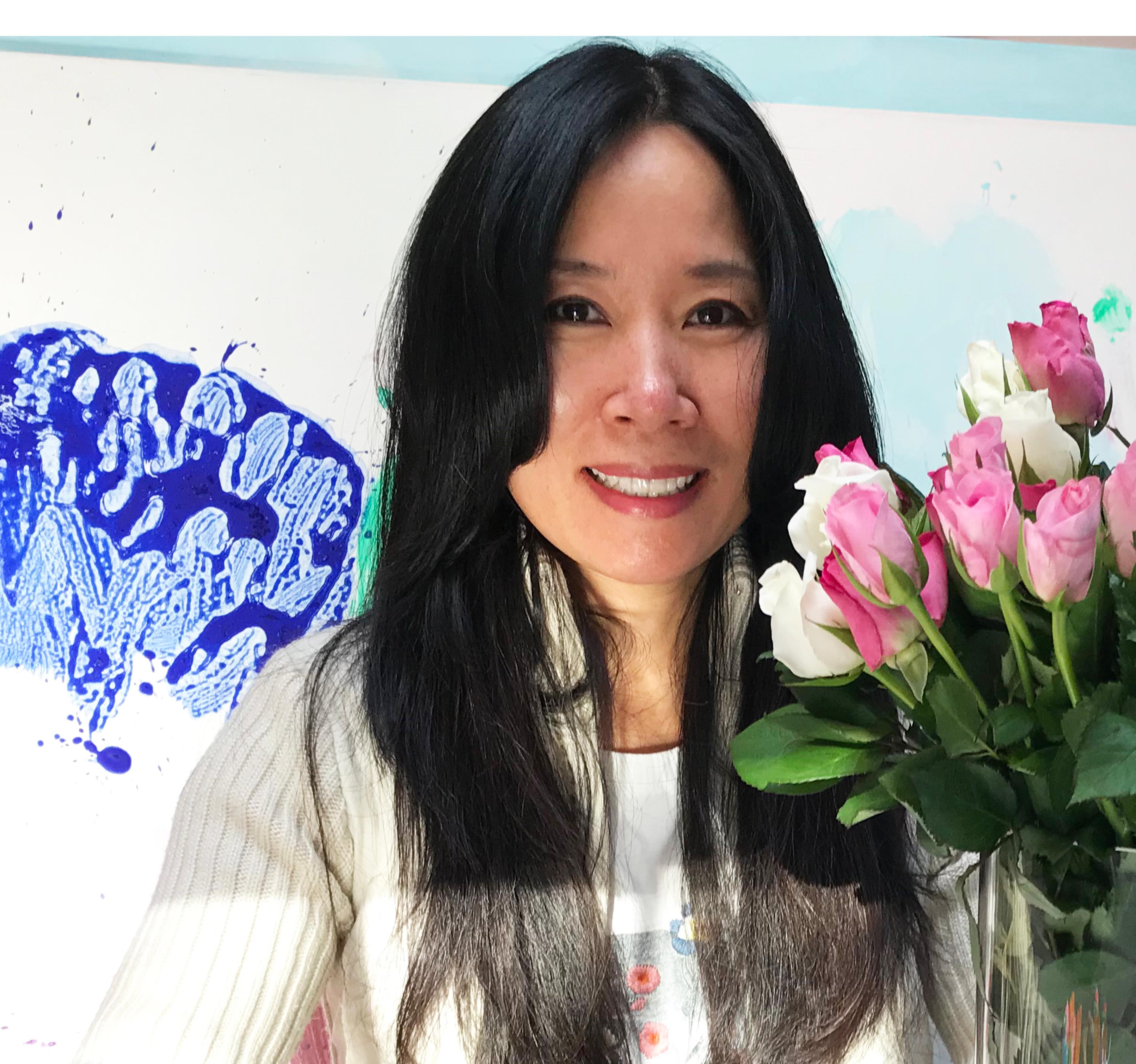 Portrait der Künstlerin Miye Lee, neben ihr eine Malerei und ein Blumenstrauß