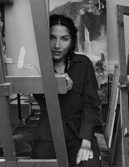Portraitfoto von Christine Brey halb verdeckt hinter einer Staffelei mit Leinwand