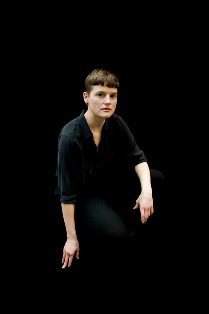 Portraitfoto von Isabell Kamp vor schwarzem Hintergrund