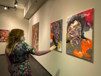 Eine Besucherin betrachtet die Kunstwerke von Claudia Mächler in der MeetFrida Pop-Up Gallery
