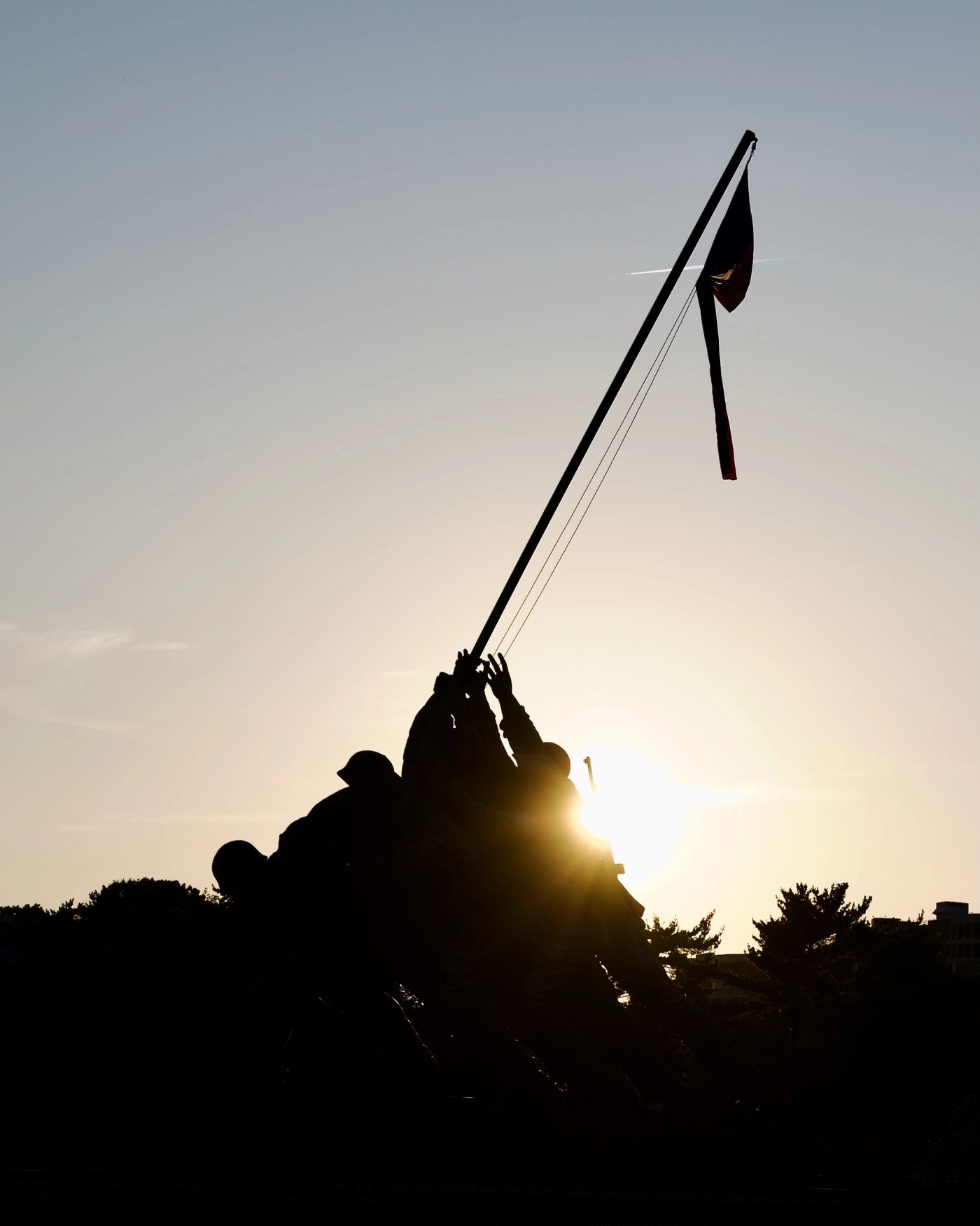 Sunset picture of USMC War Memorial with sun peeking behind the soldiers raising the flag