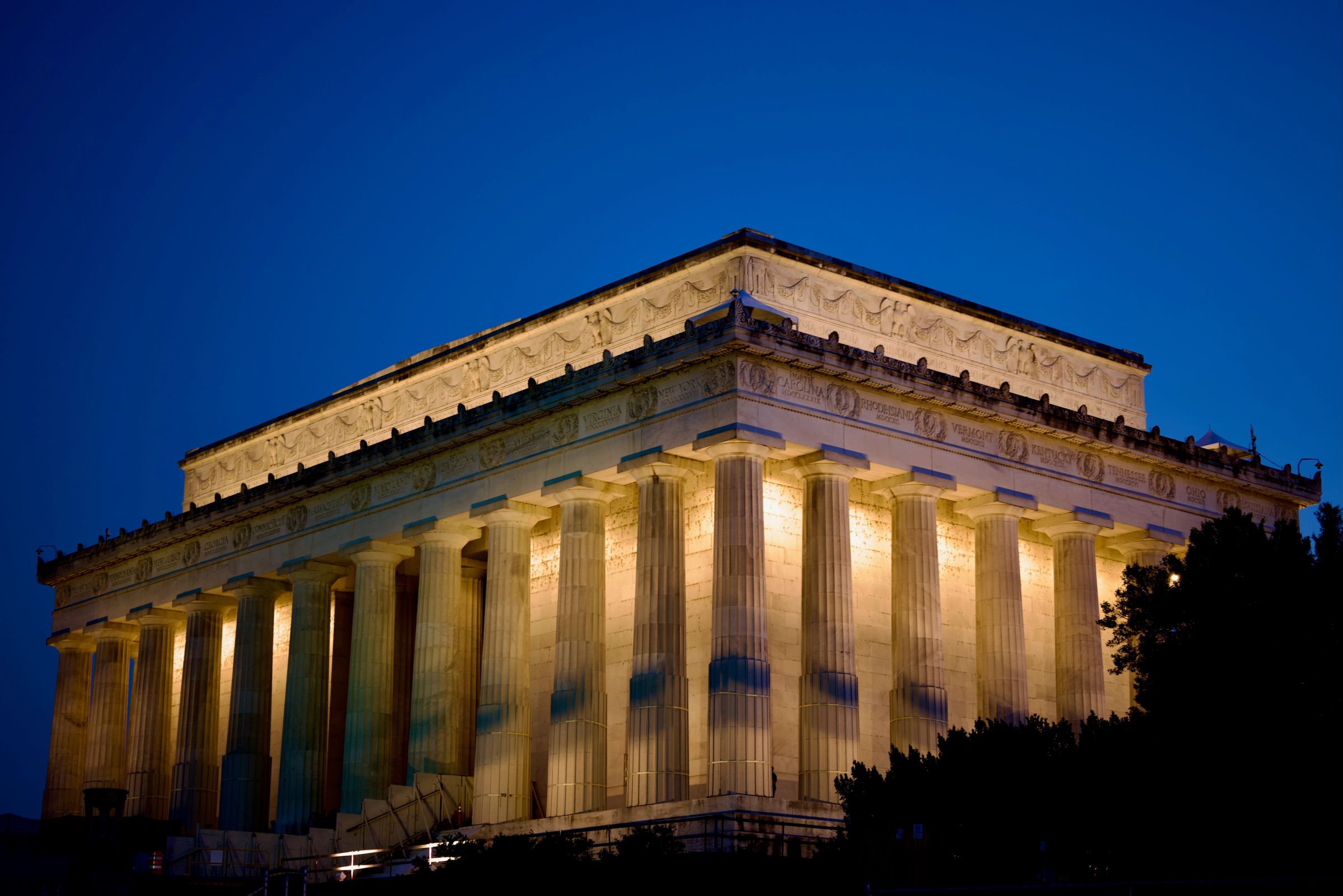 Gloriously lit Lincoln Memorial in Washington, DC. Late evening, clear blue sky contrasts with lights used to illuminate the landmakr