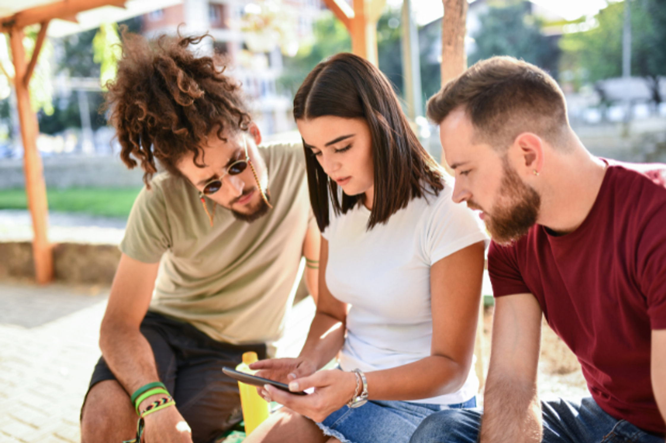 3 friends looking at a phone together