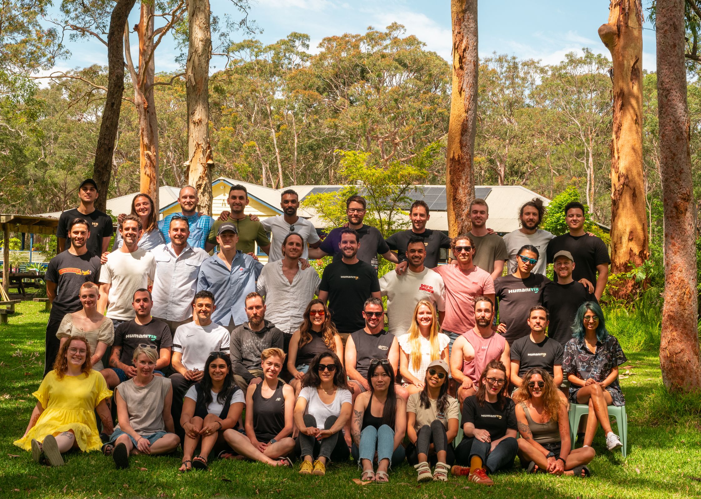 Photo of Humanitix team against a backdrop of gum trees and green grass