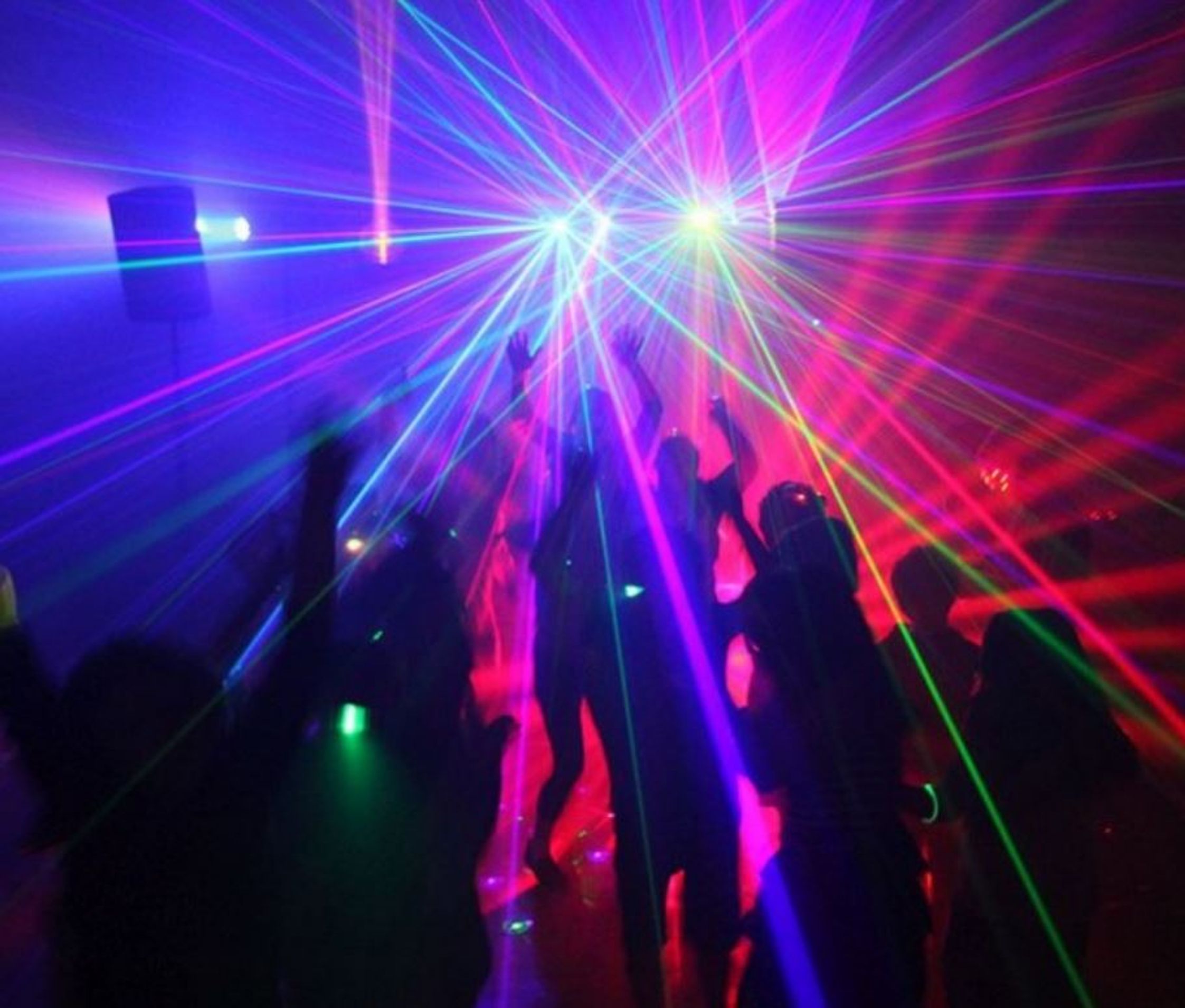 Image is from everything glows, this photo shows students partying with laser lights in the background