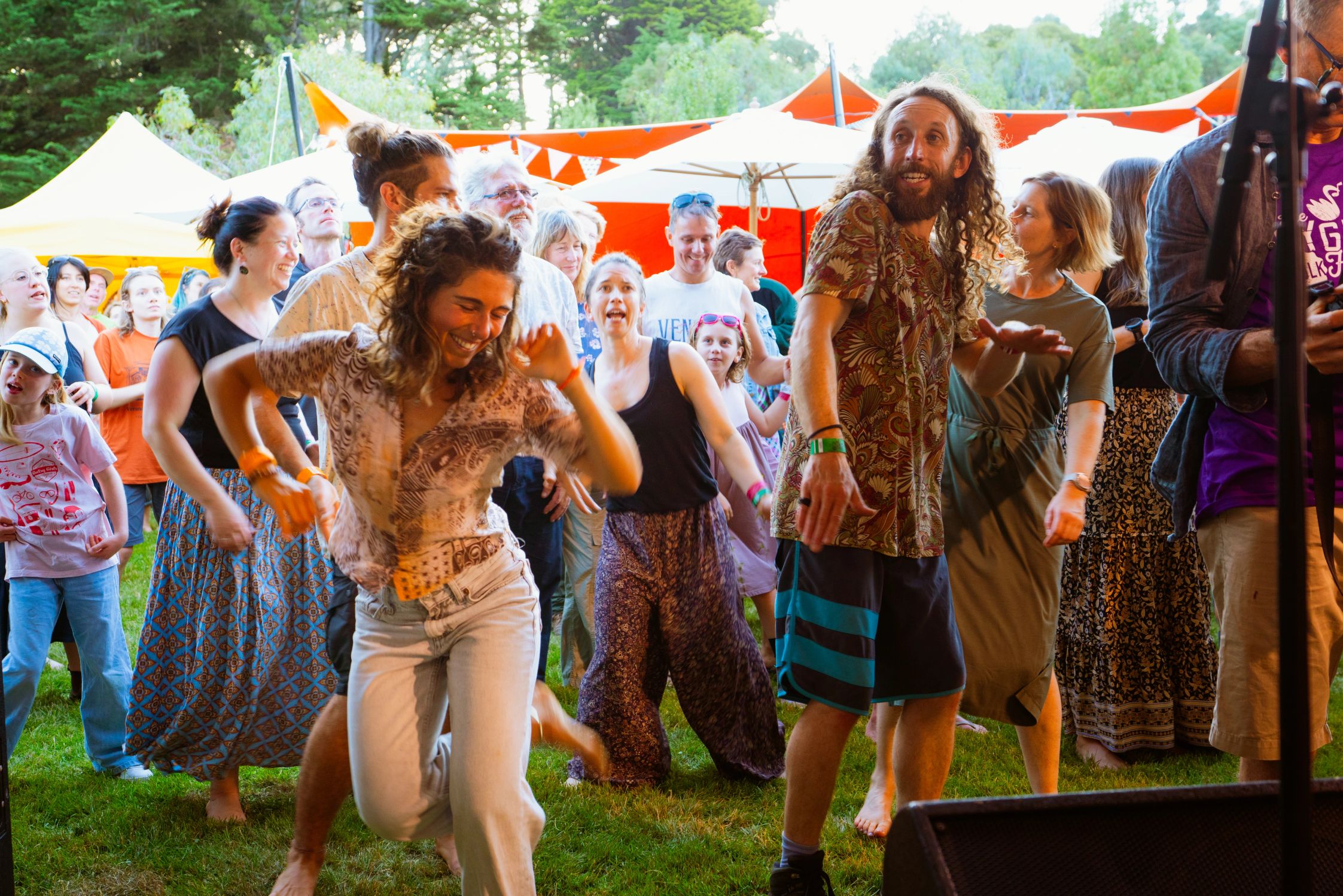 Happy festival-goers dancing in front of the stage during the day