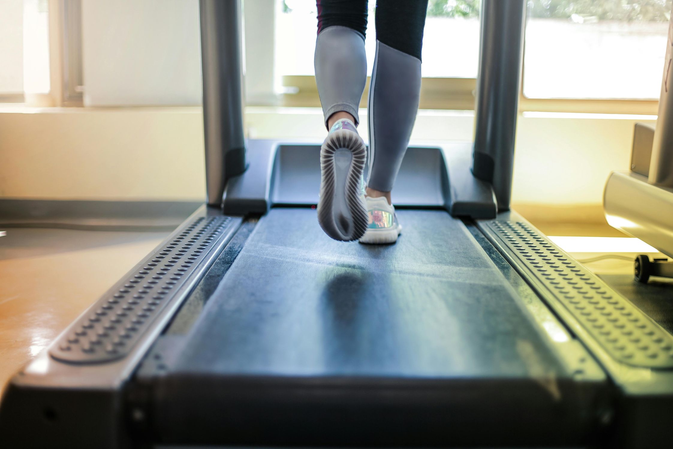 A close-up of legs running on a treadmill