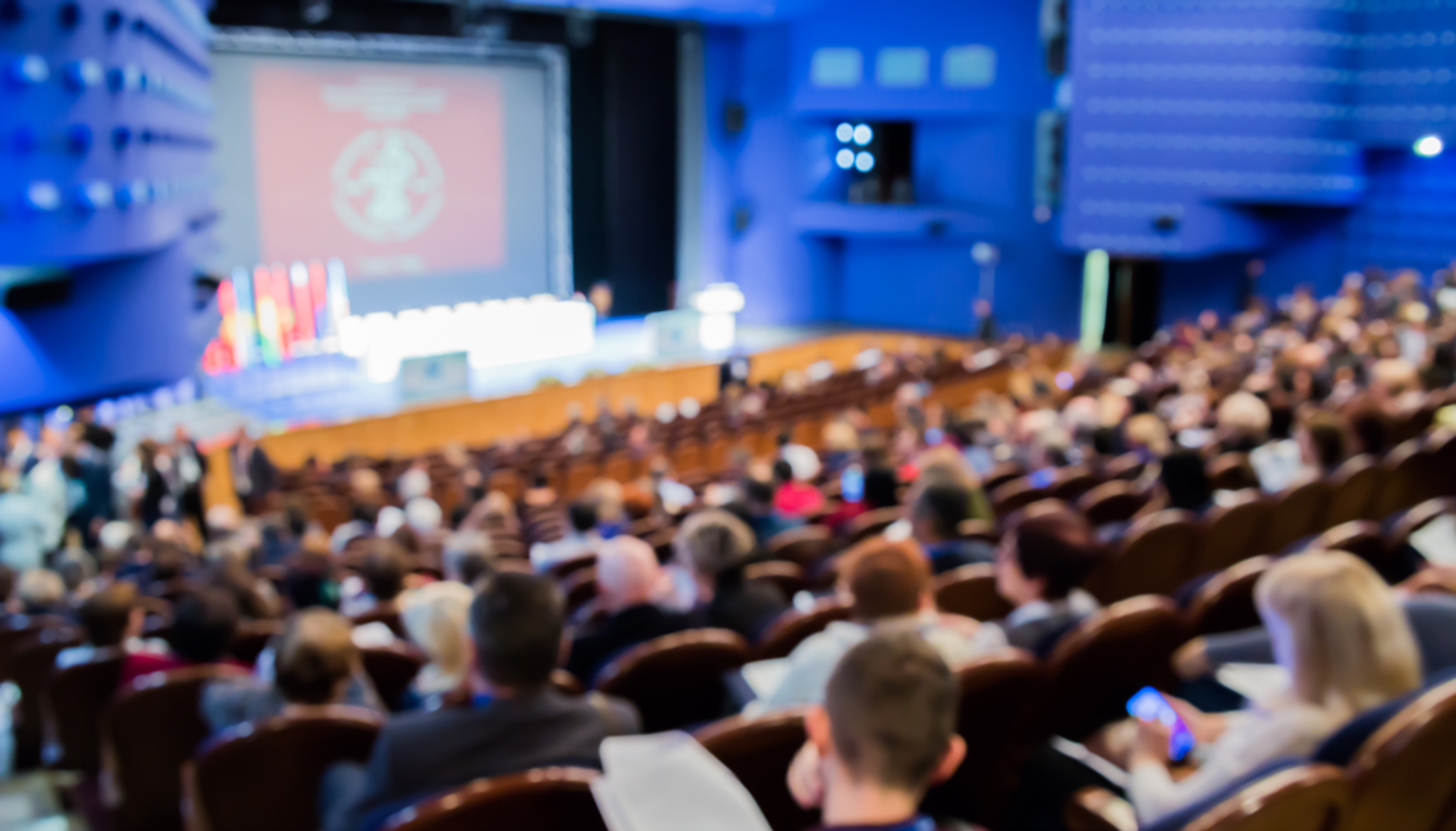 Thousands of attendees sitting, listening to a successful seminar 