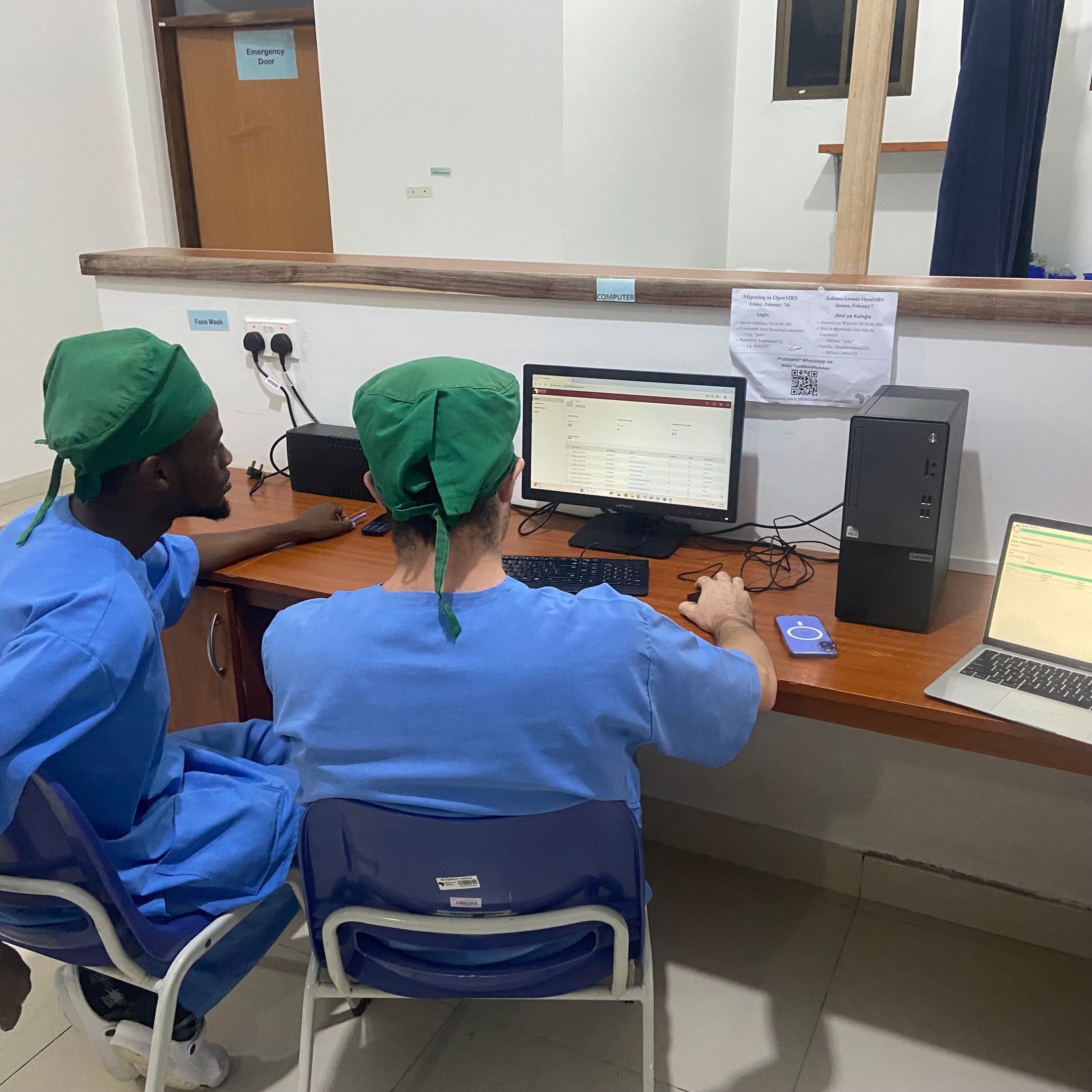 Two hopsital staff looking at a desktop computer