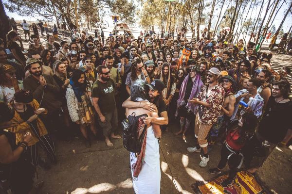Photo of Luke hugging another punter as surrounding festival-goers smile and look on