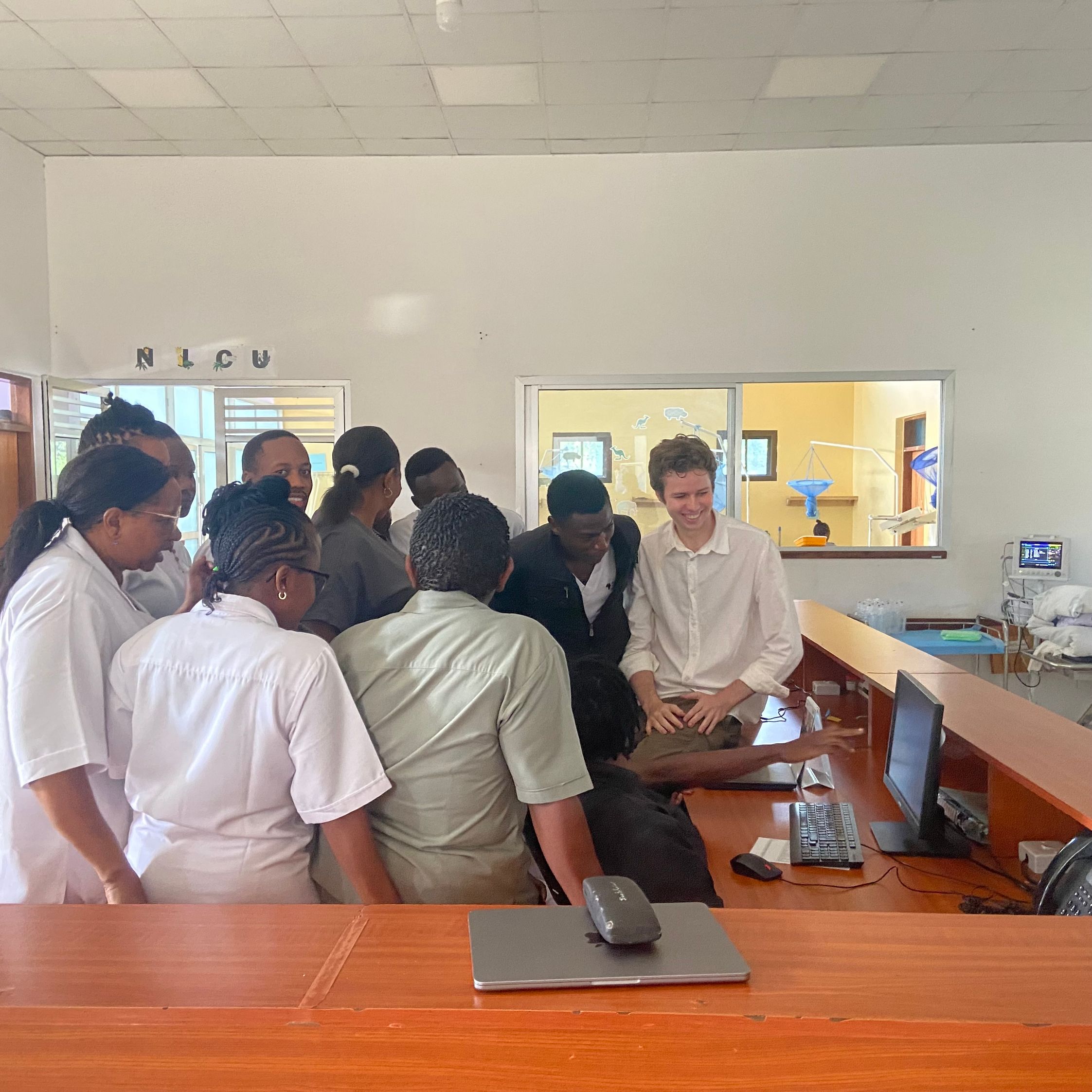 People crowded around one desktop computer at the hospital