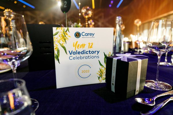 A card on a gala table which reacds Carey Year 12 Valedictory Celebrations 2022