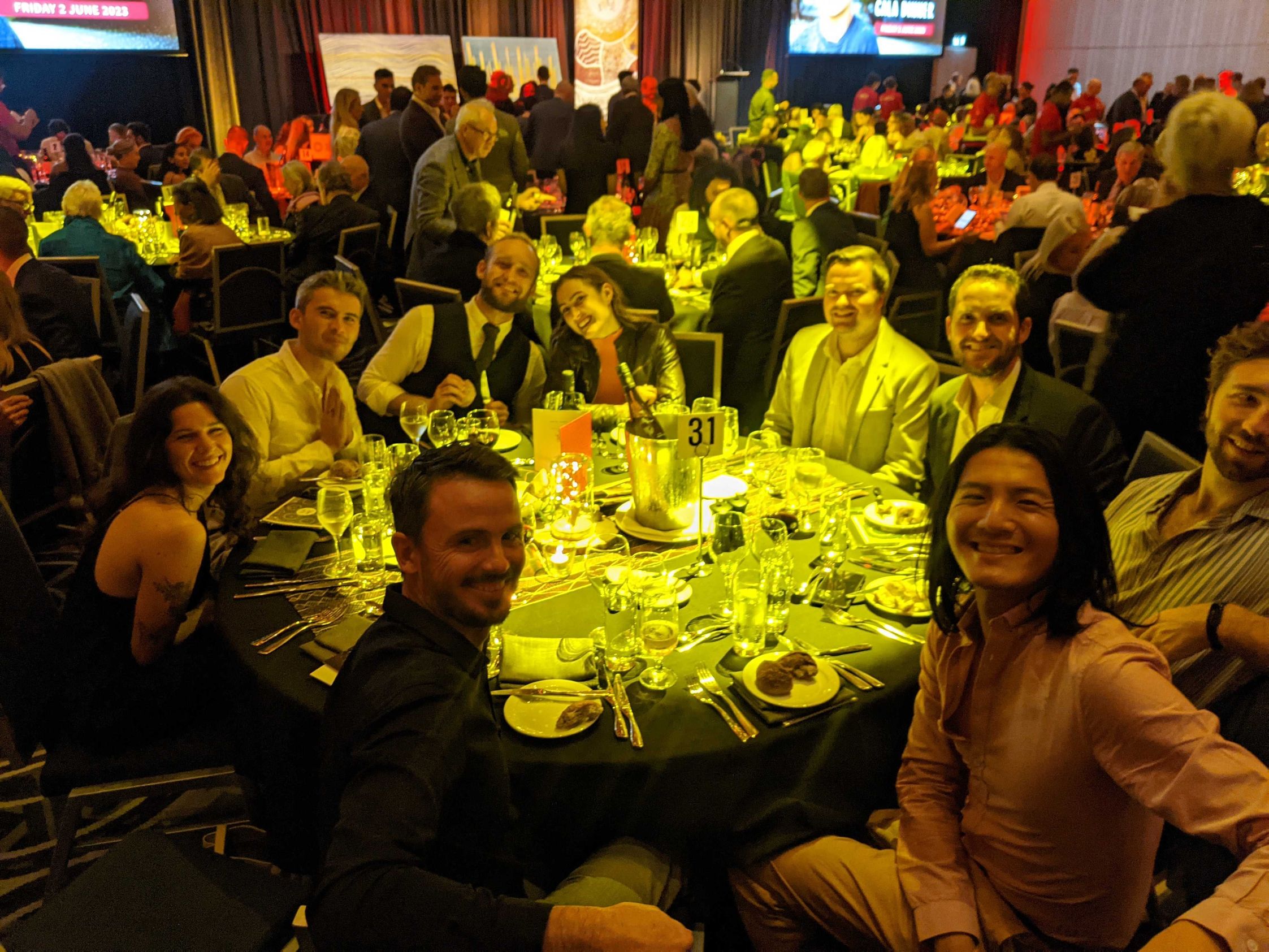The Humanitix team sitting around a table at the gala dinner