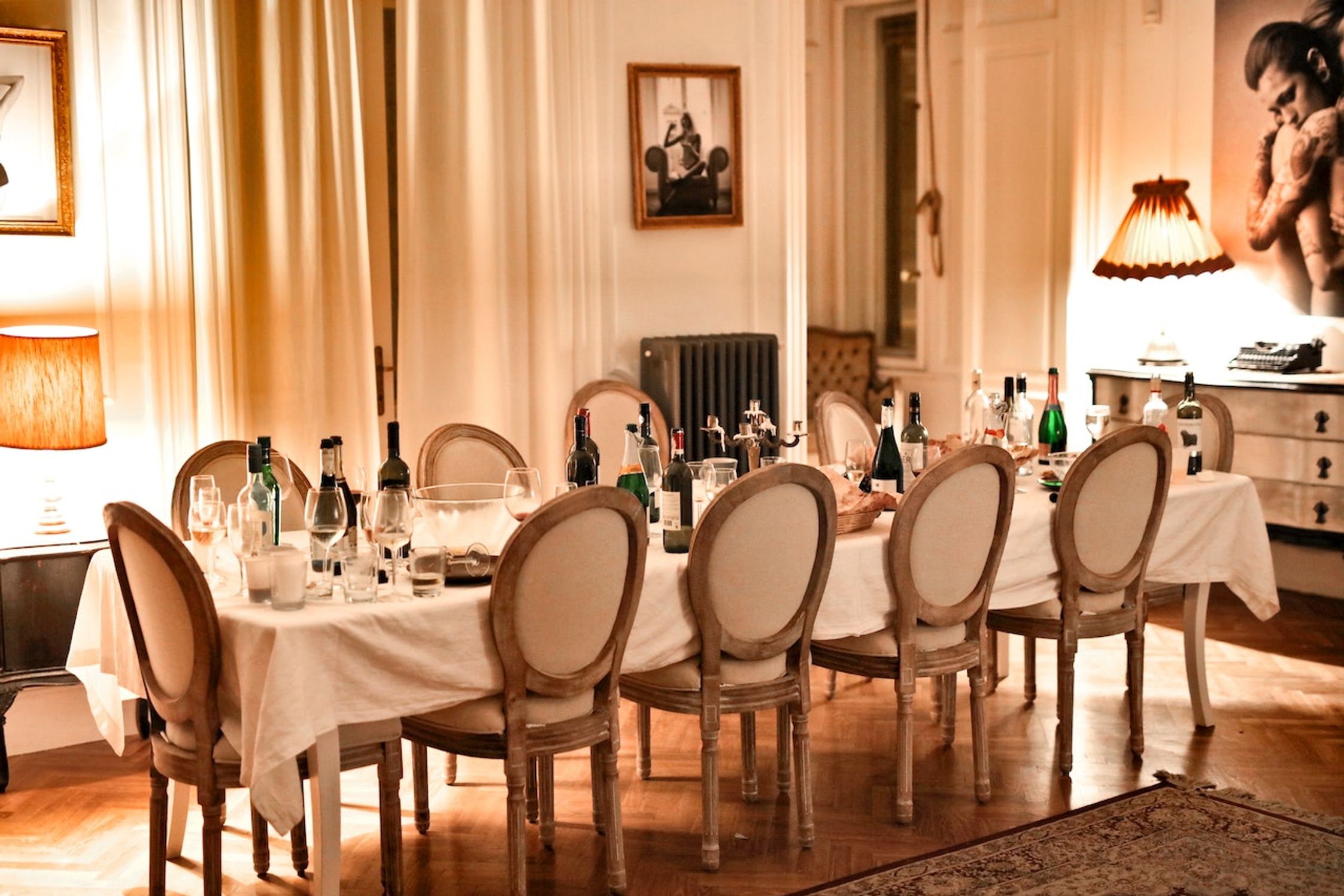 A long table with empty glasses and wine bottles