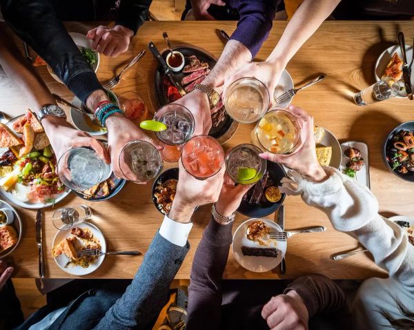 This image is from Thrillist, it contains people bonding over food and drinks