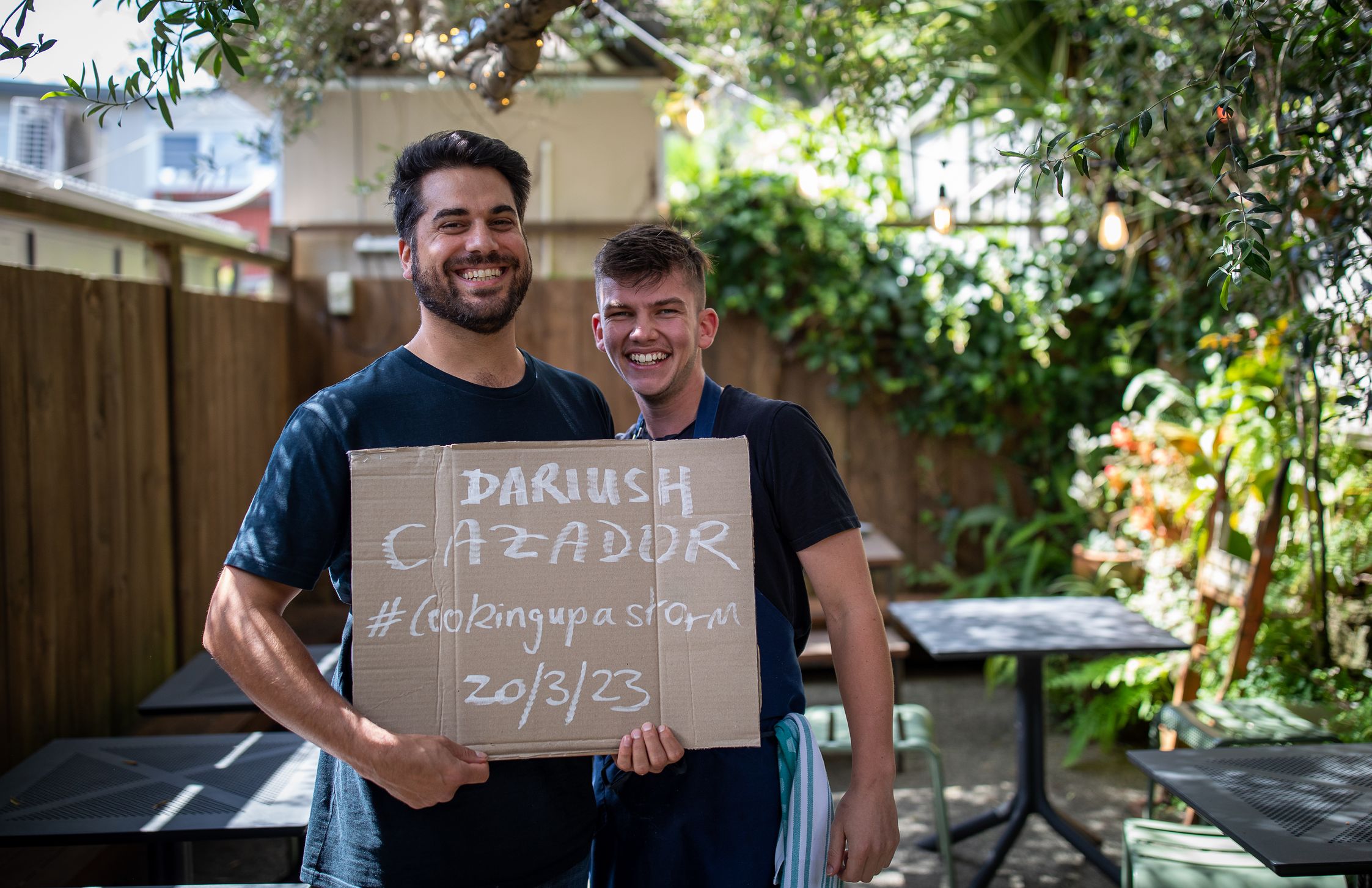 Chefs holding cardboard sign saying Darush Cazador #cookingupastorm 20/03/23