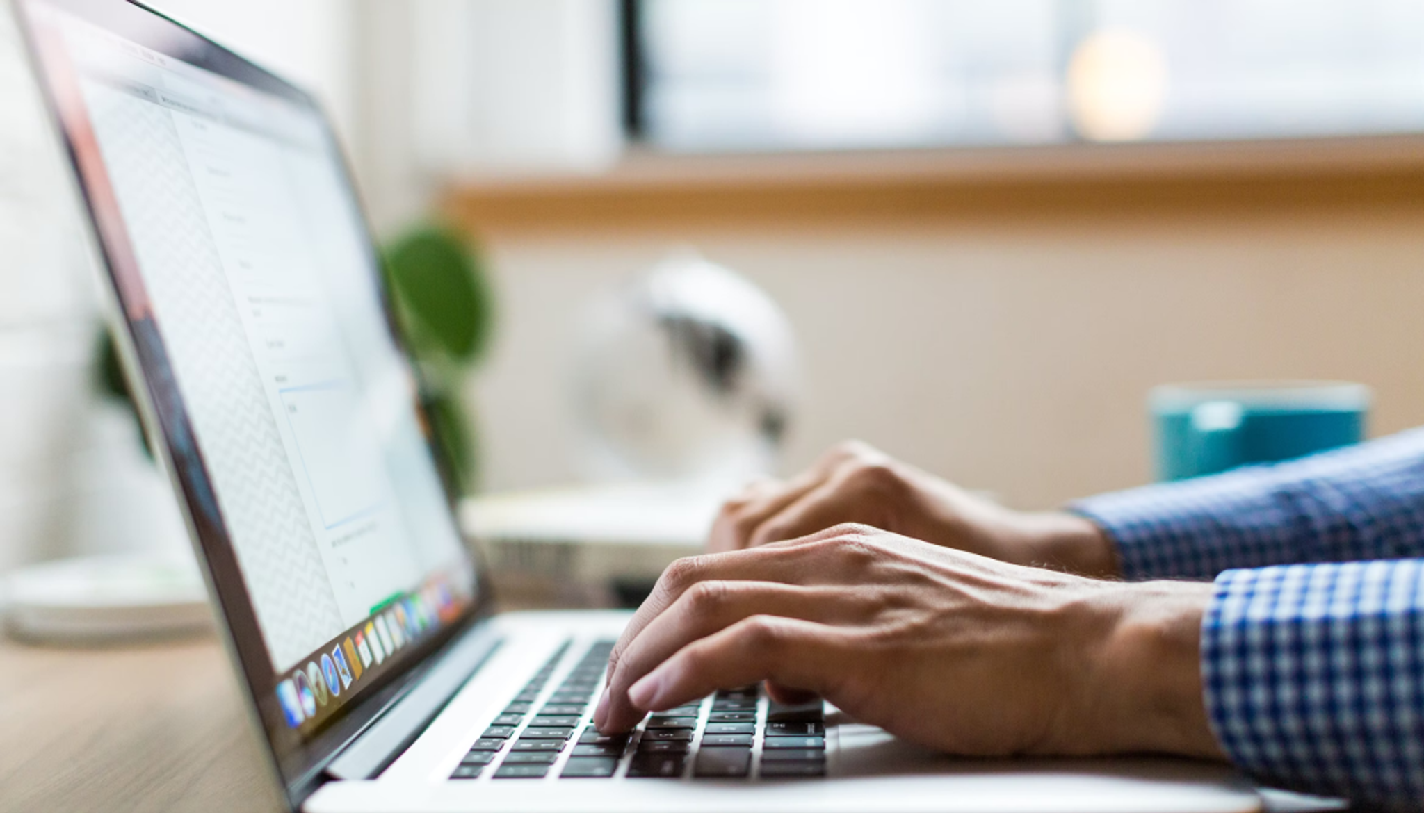 Image above contains: Laptop to the left of the screen with male typing a killer speaker bio