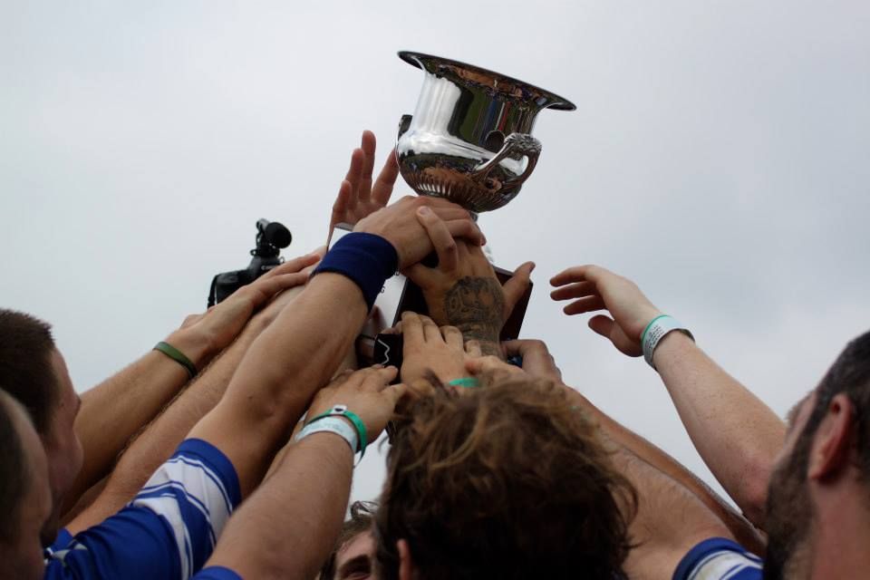 Bunch of hands holding a silver trophy in the air