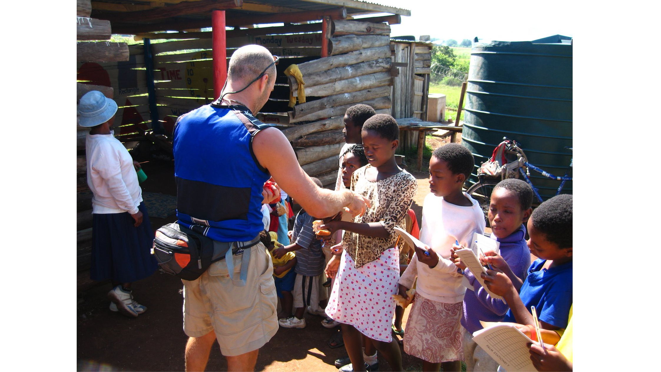 Founder of PIE handing out stationary to kids