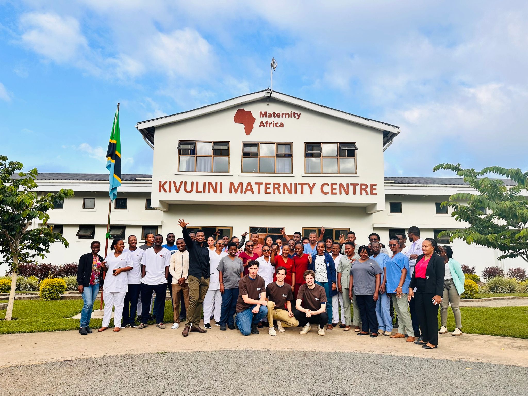 Nathan, his friends and the hospital staff in front of the Kivuluni Maternity Centre in Tanzania