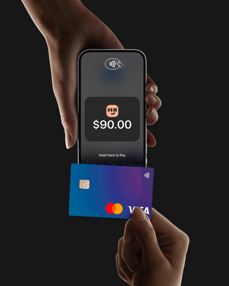 A hand holding a phone with the Humanitix for Hosts app taking a contactless card payment via Tap to Pay