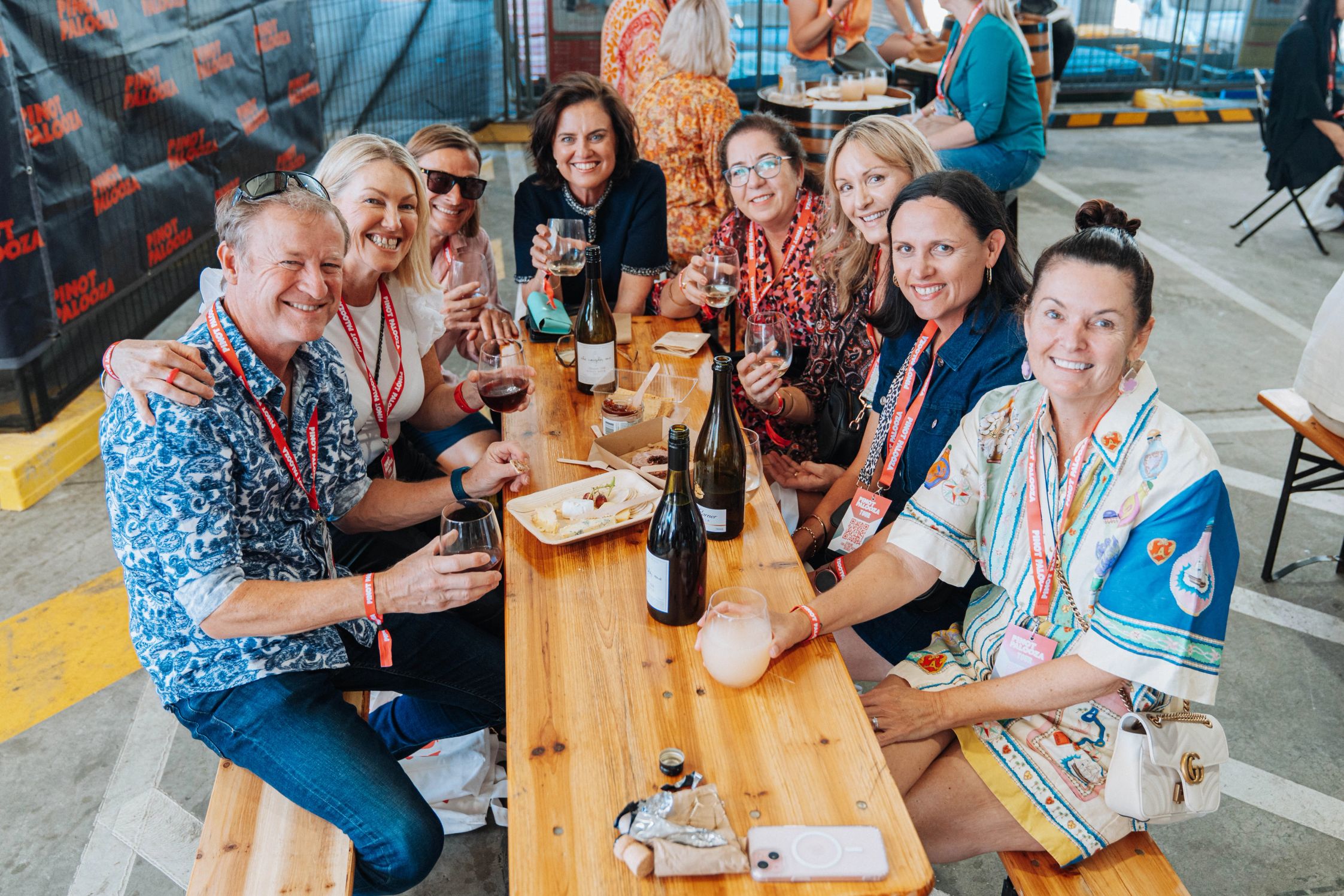 Happy attendees sitting at a table enjoying wine and cheese at the Brisbane event