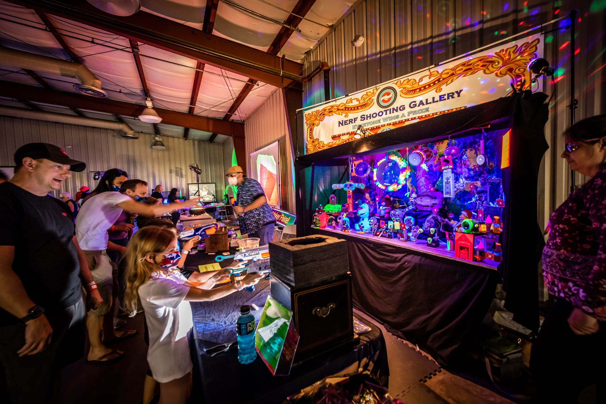 Kids playing at the Nerf Shooting Gallery lit up in neon at the Maker Faire