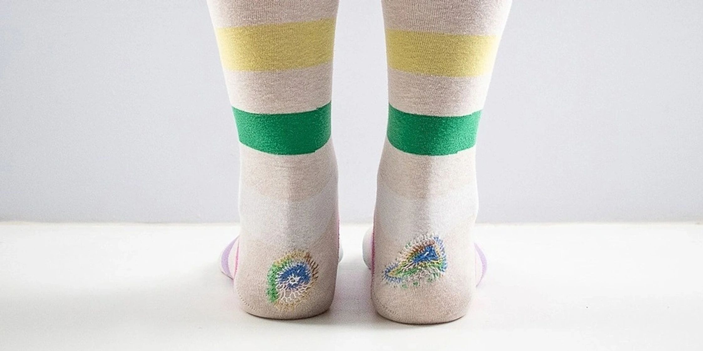Stripey socks that have been mended with a cool pattern