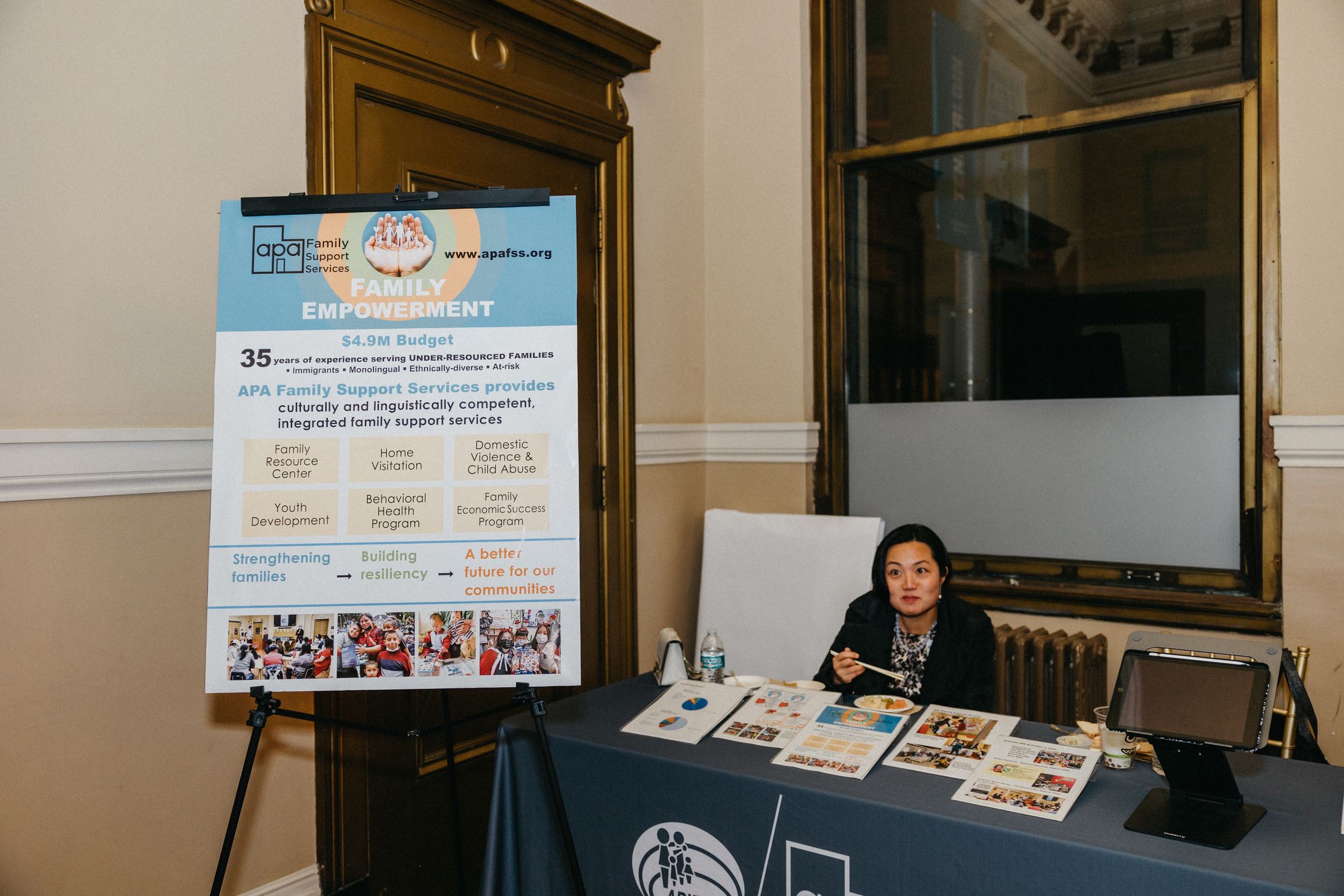A woman sitting at a table with a big poster that says Family Empowerment