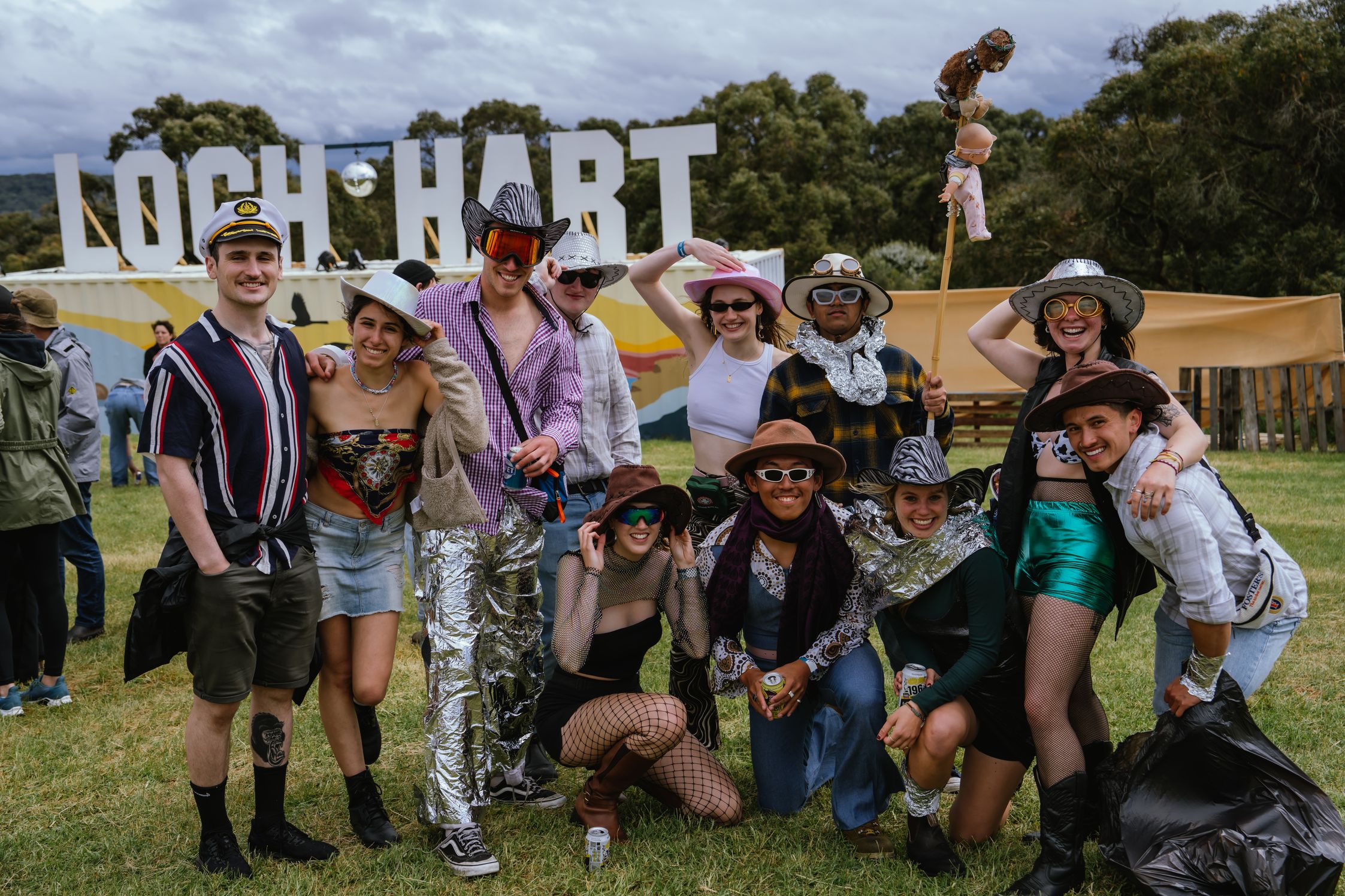 A group of dressed-up attendees in front of the Loch Hart sign