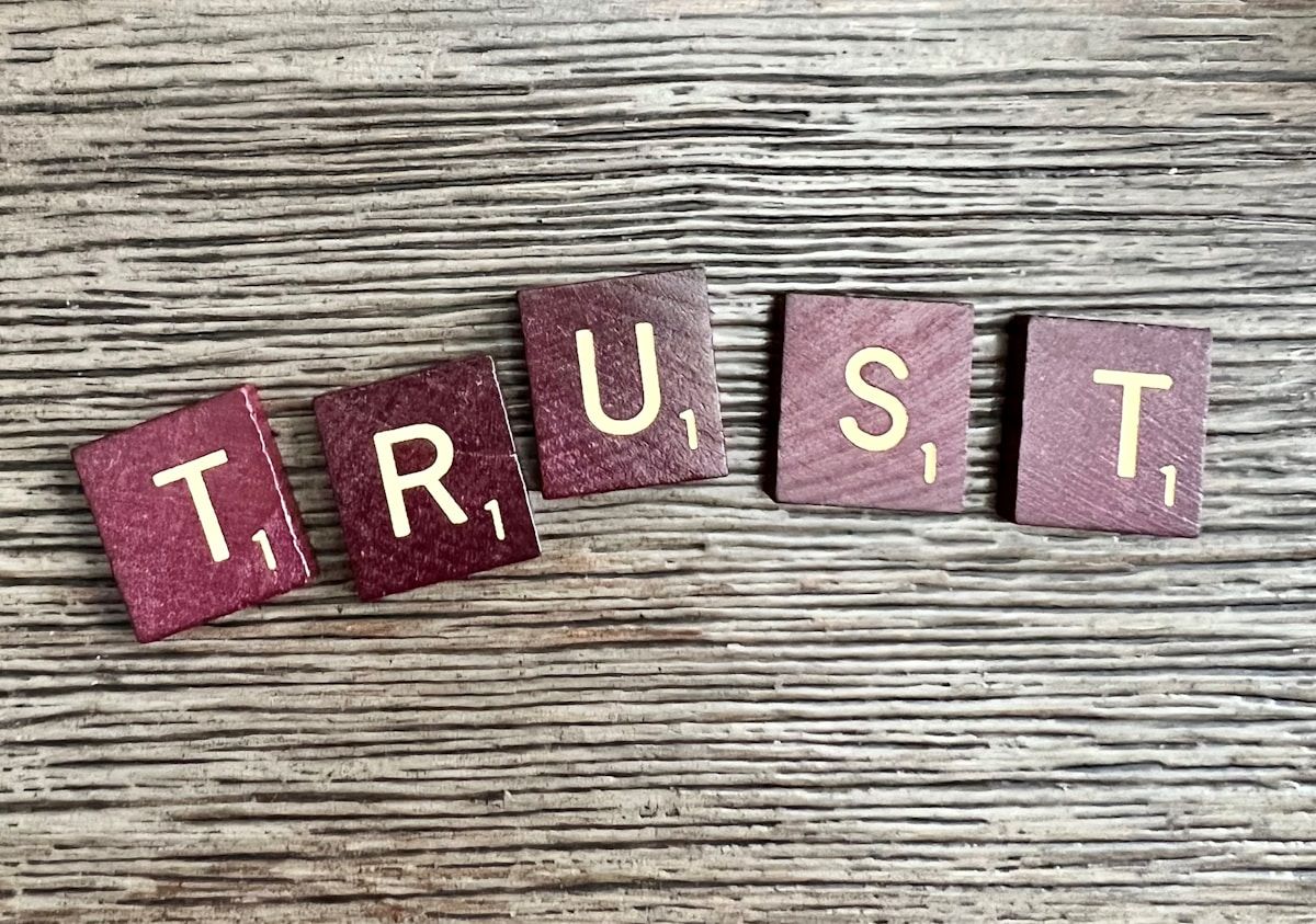 trust spelled with wooden letter blocks on a table