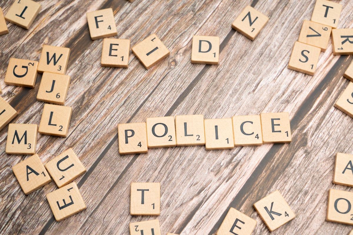 scrabble tiles spelling police on a wooden table