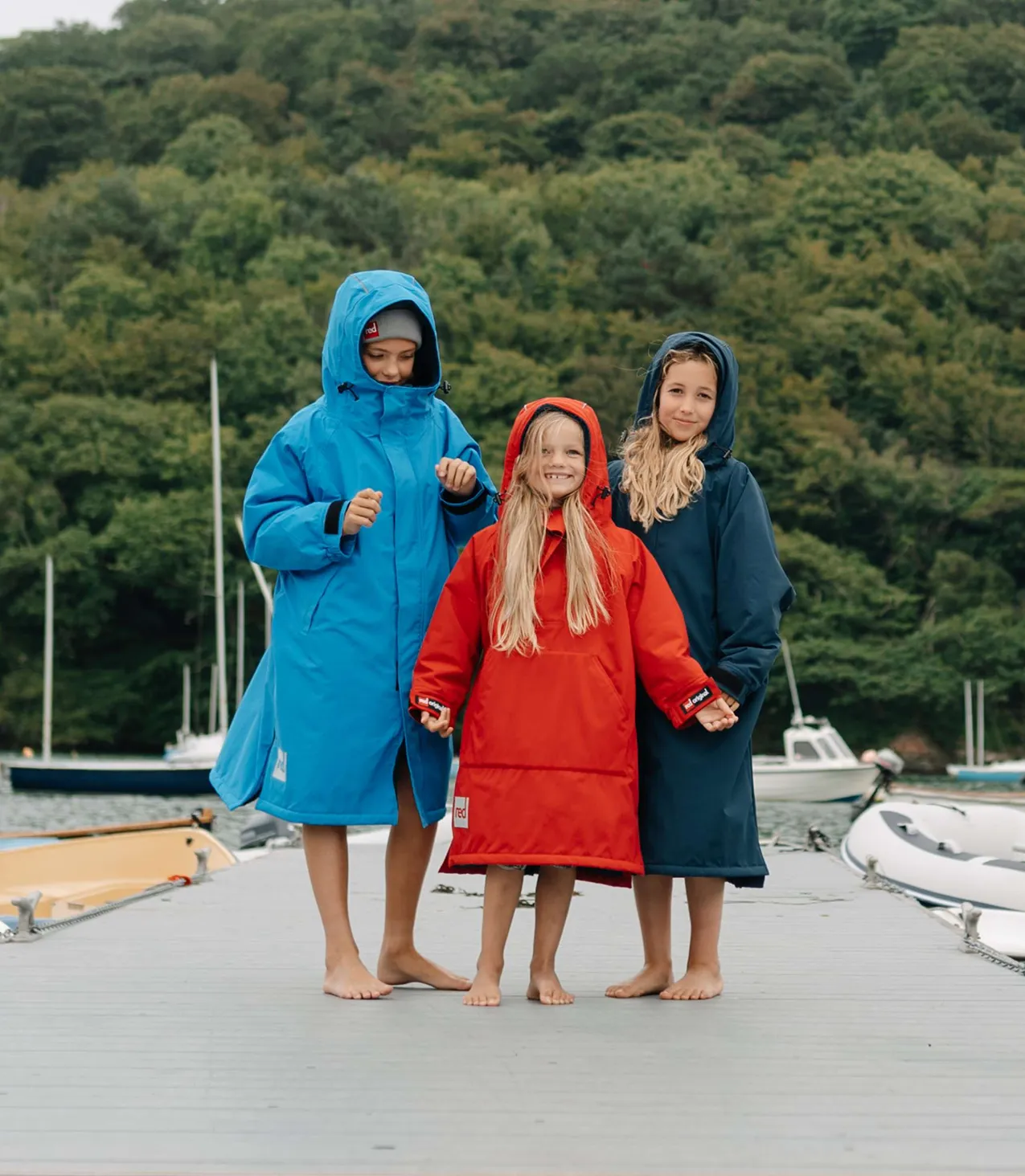 Three children on a dock with waterproof jackets