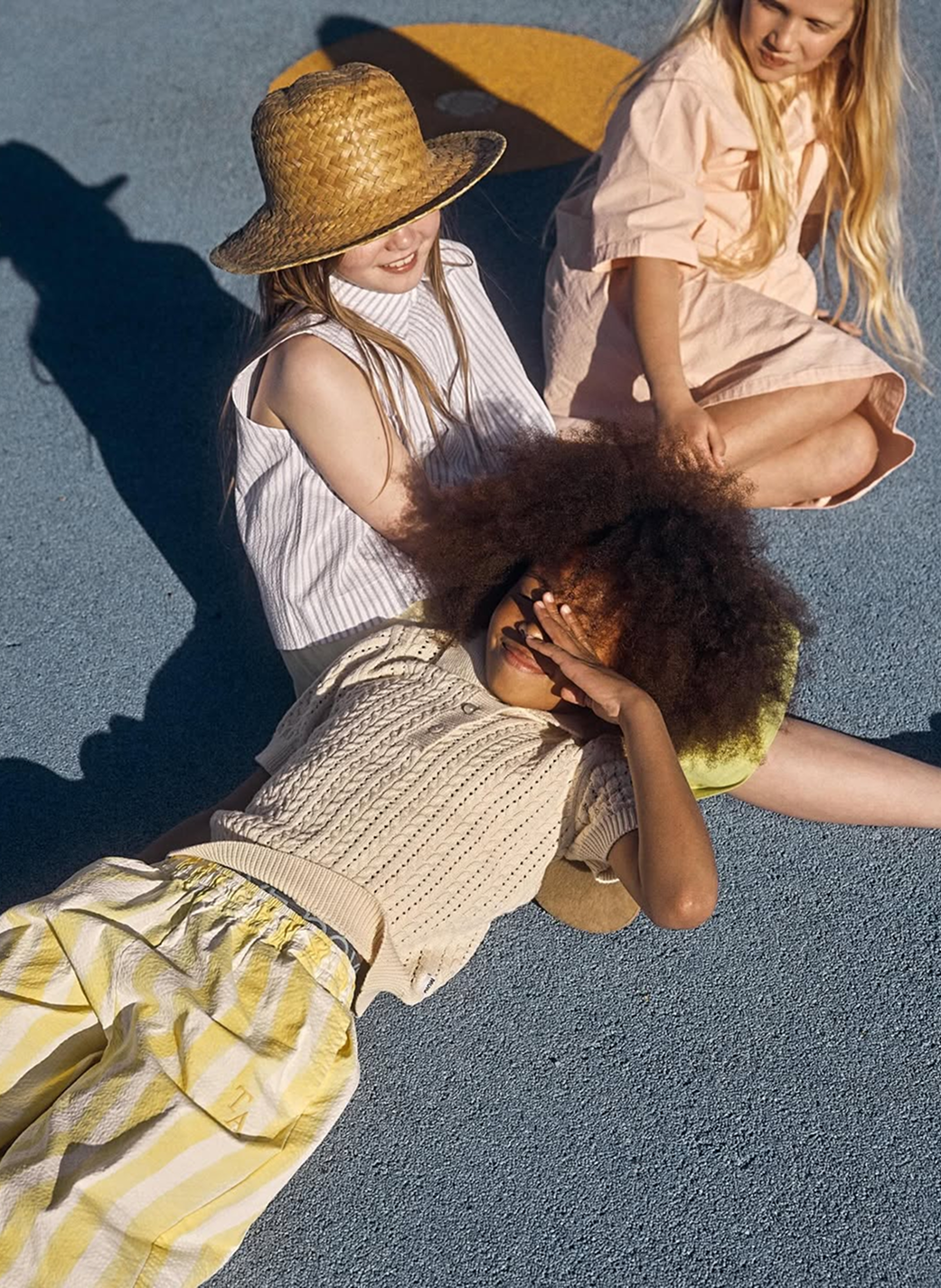 Three female models laying down in the sun