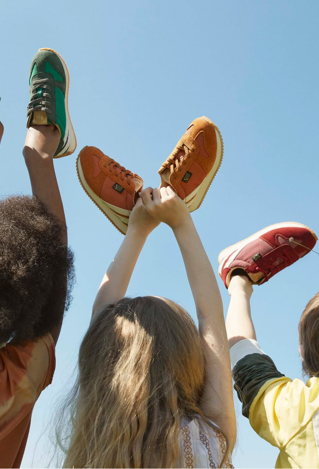 Children holding Young Soles shoes in the air