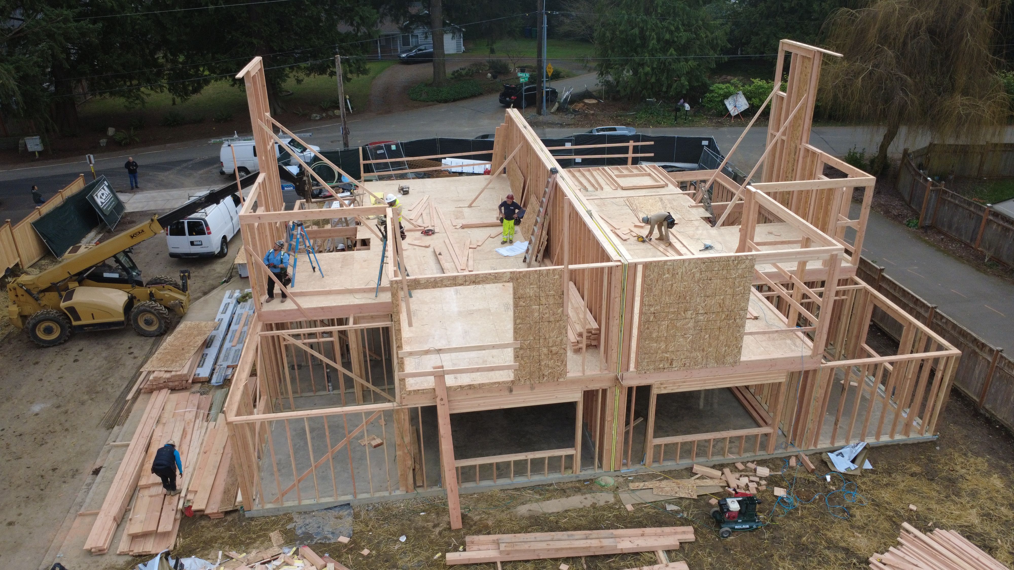 Active new construction site showing open framing, sub-floor work, and structural elements