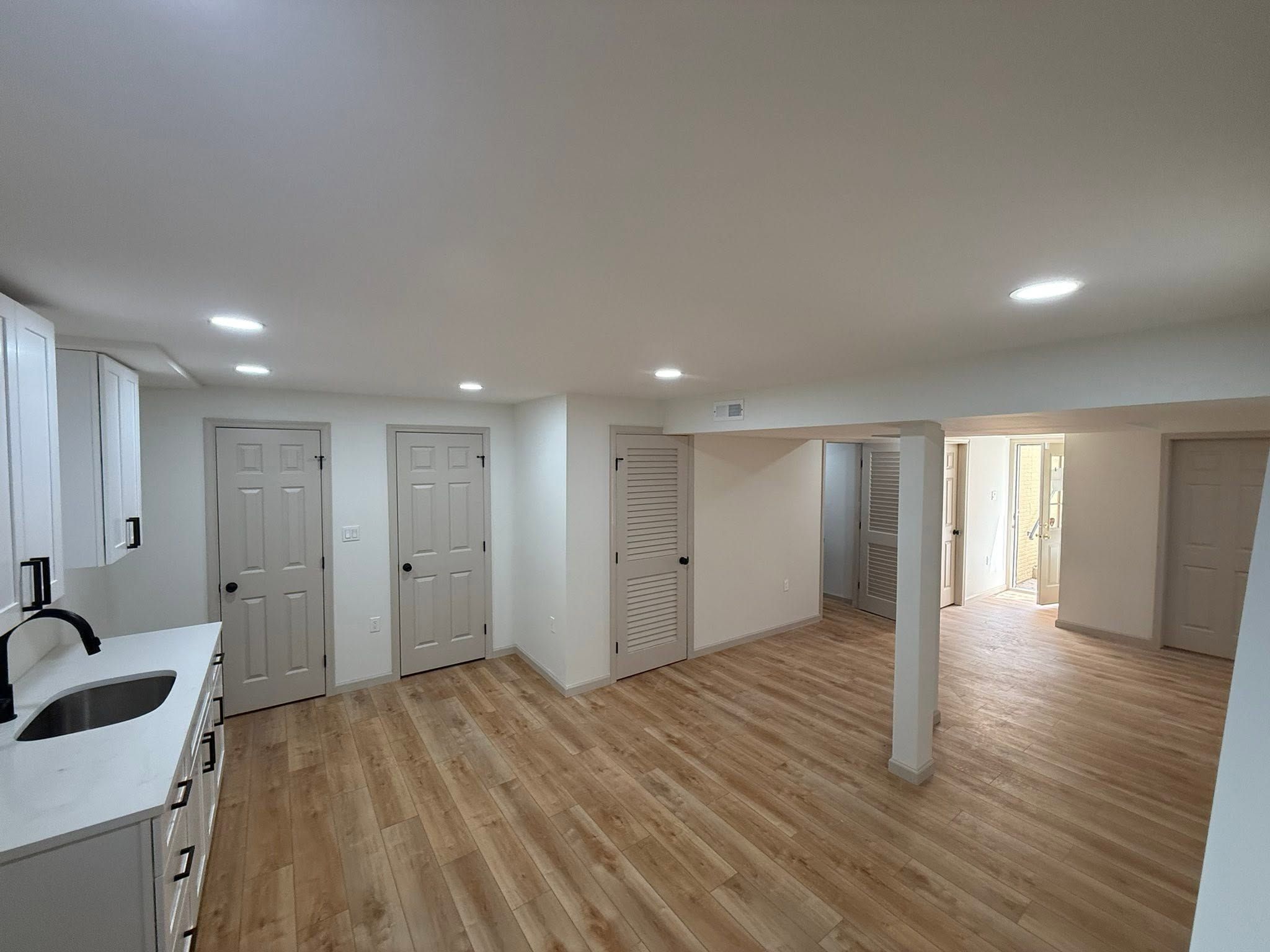 Finished basement remodel with new flooring, recessed lighting, and open floor plan
