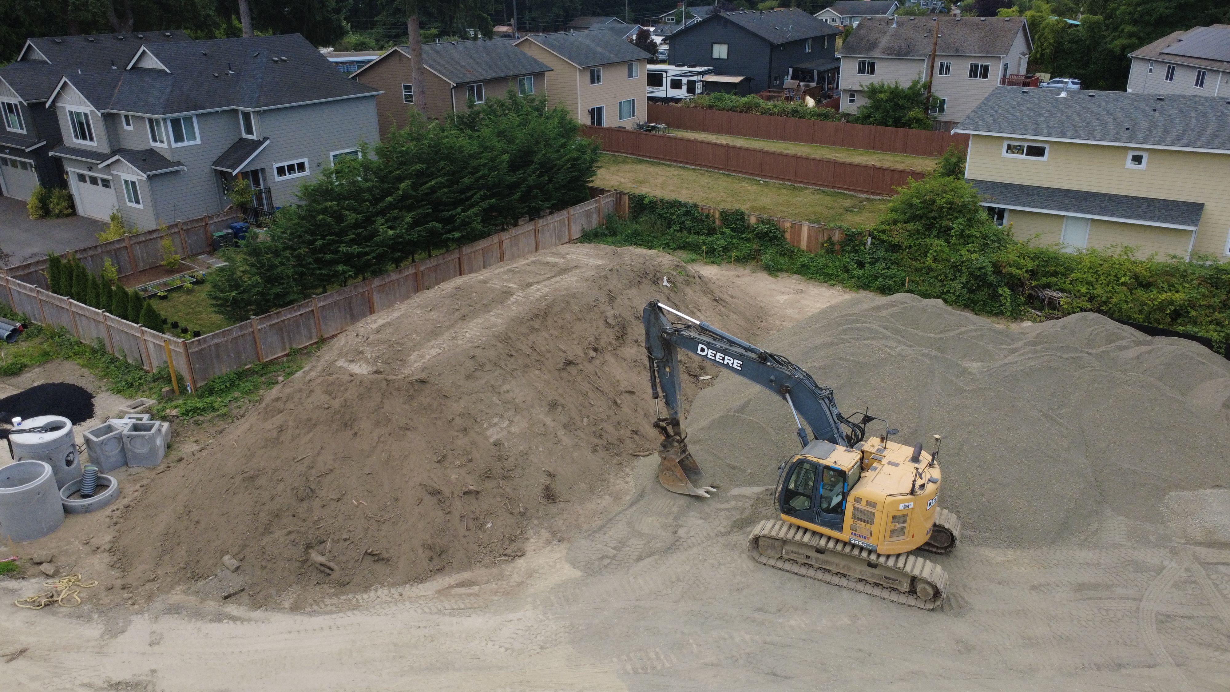 Excavation pit alongside a foundation wall showing site preparation work