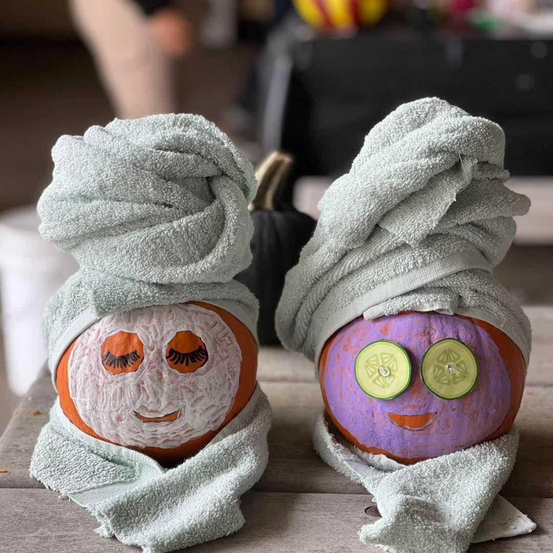 Three pale pumpkins on a stone step, one carved with a quilted pattern, one studded with pearls and one tied with a black satin bow