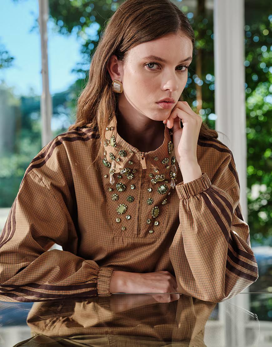 Jewel embellishments around the funnel neck of the brown check overhead track jacket