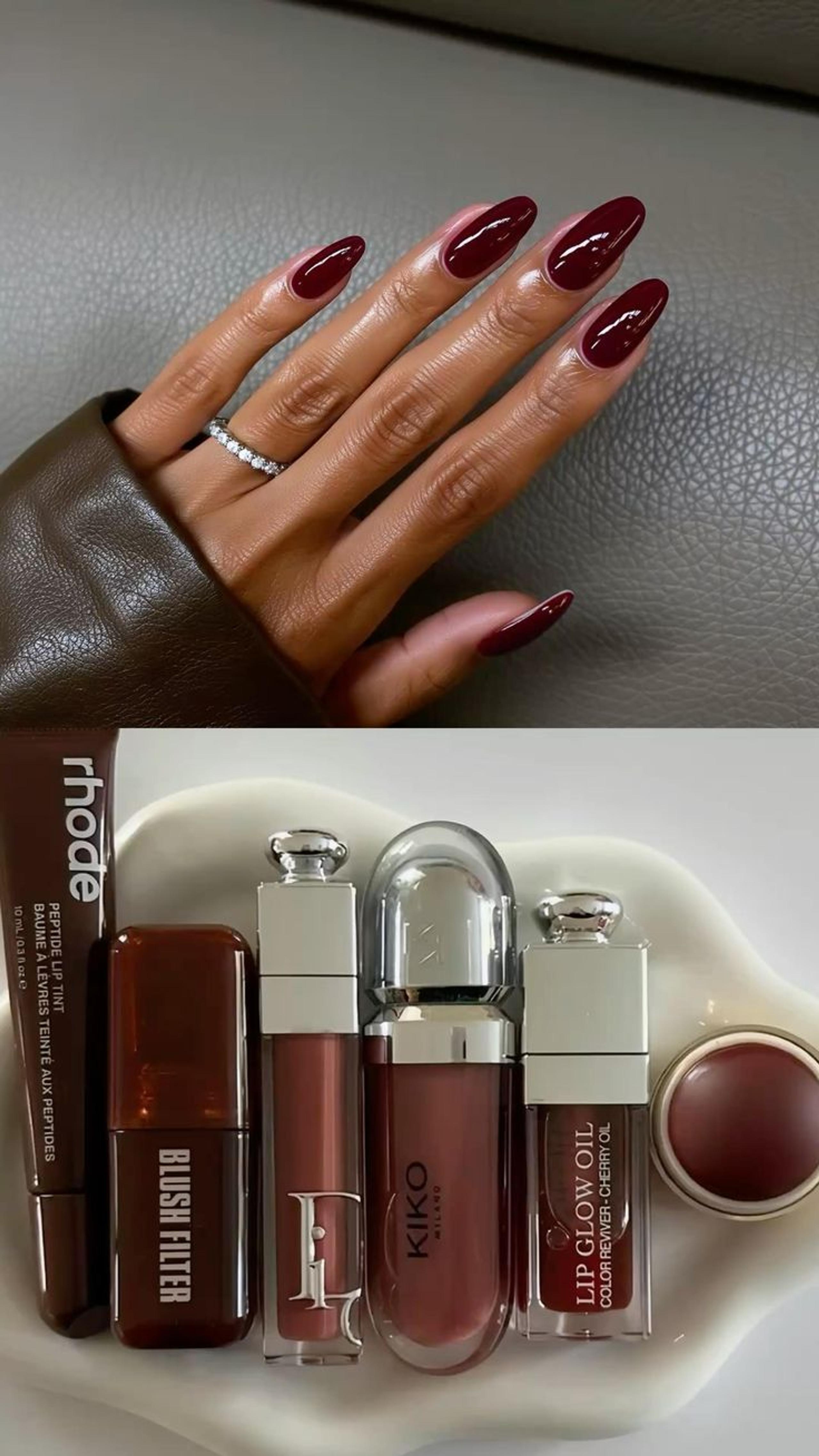 Glossy burgundy almond nails beside Rhode, Dior and Kiko lip and cheek products in matching berry shades