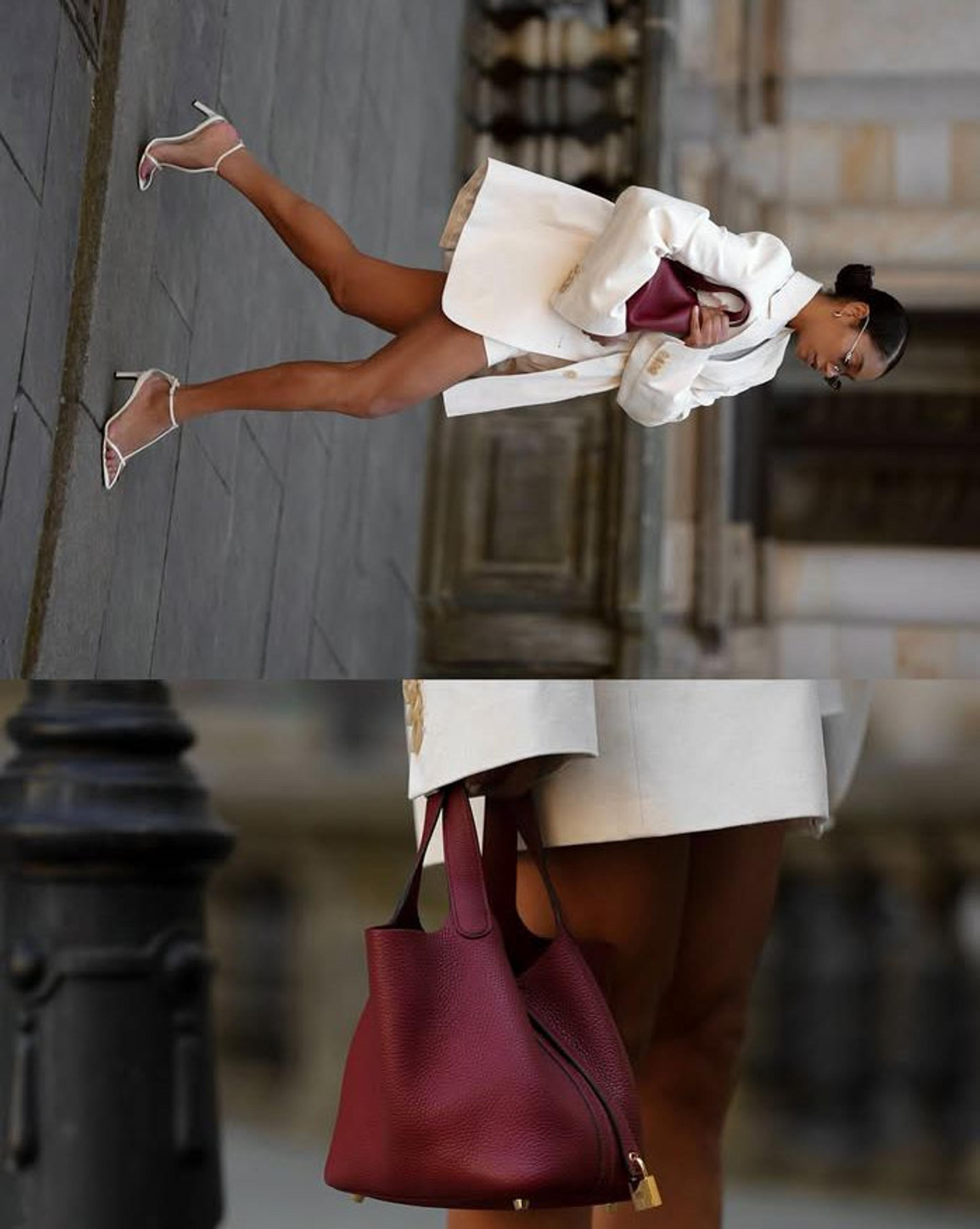 Woman in a white blazer carrying a burgundy leather bag