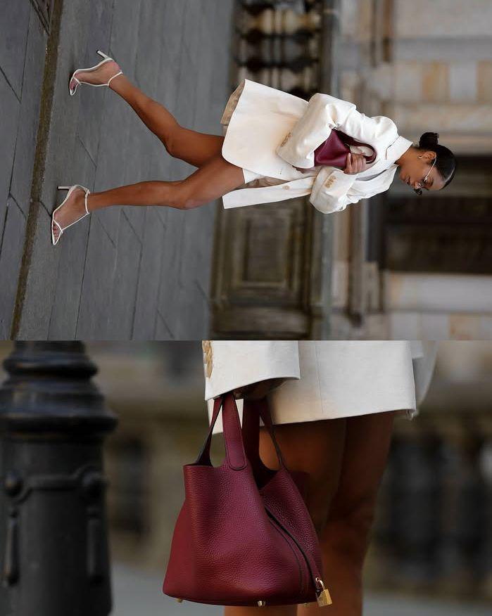 Woman in a white blazer carrying a burgundy leather bag