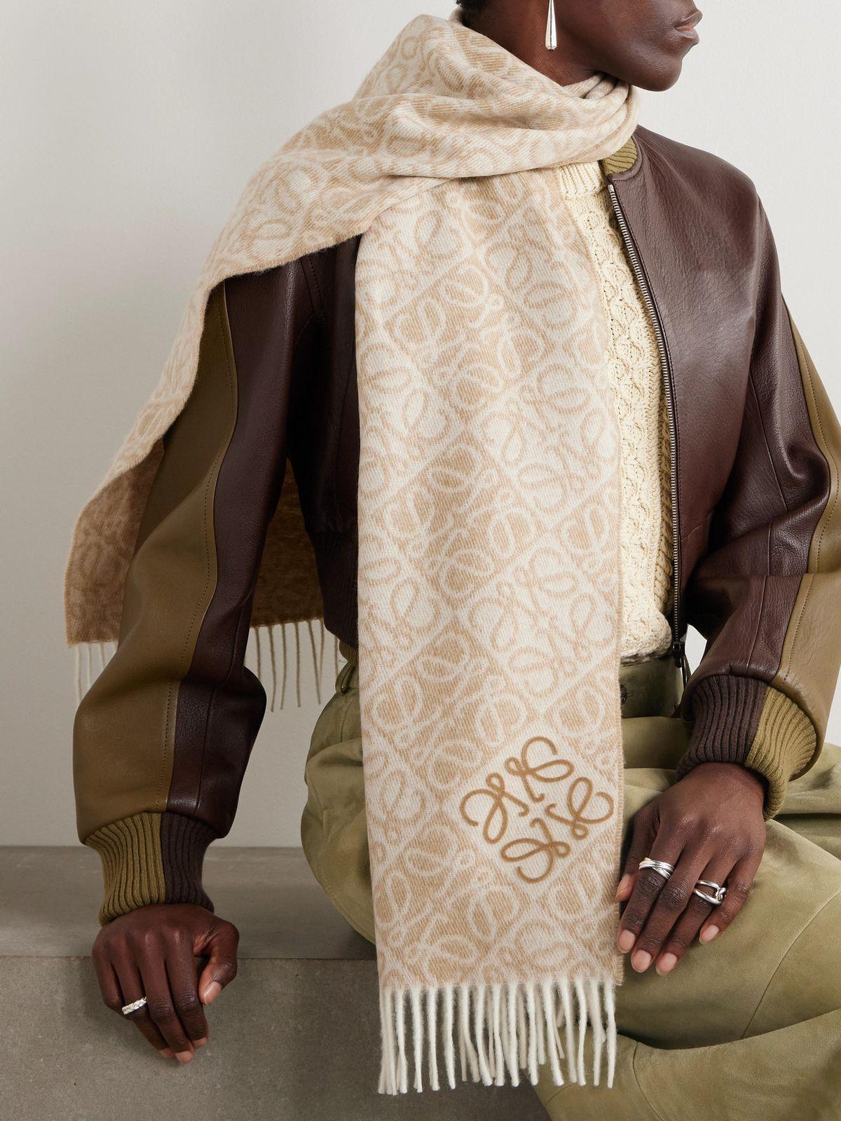 Camel wool coat, leather boots, cashmere jumper and leather bag laid out as winter investment pieces