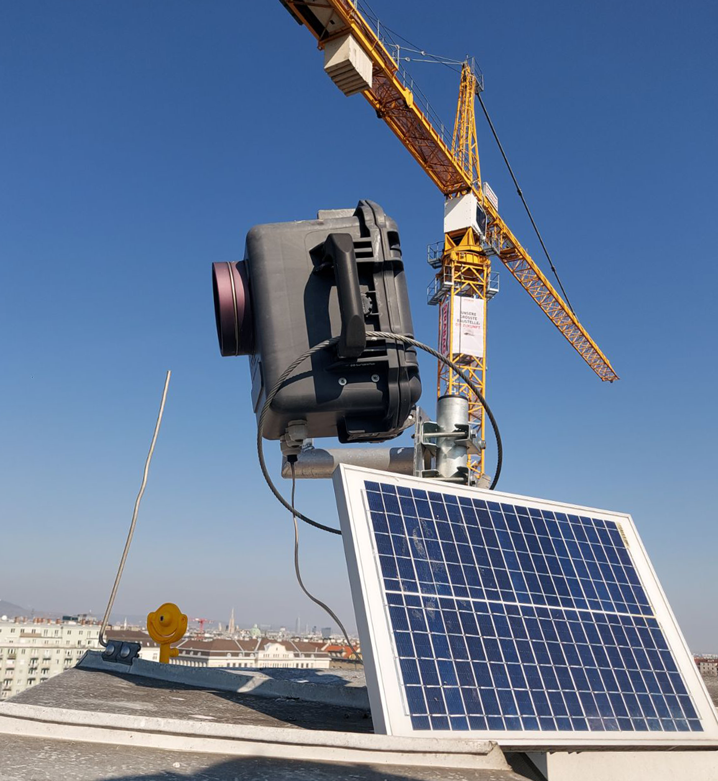 A construction timelapse camera with solar panel and crane