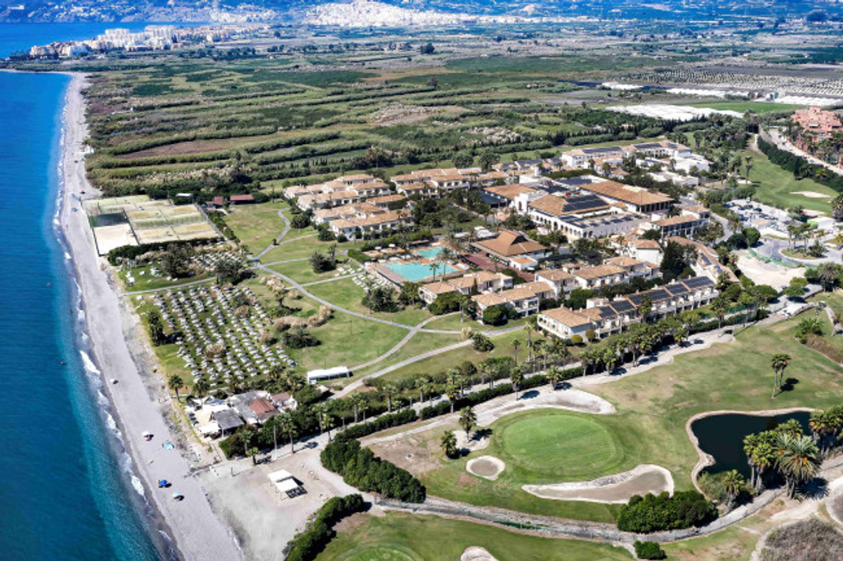 Aerial view of the Impressive Punta Cana resort property showing hotel buildings, landscaped grounds, swimming pools, and beach access along the coastline.